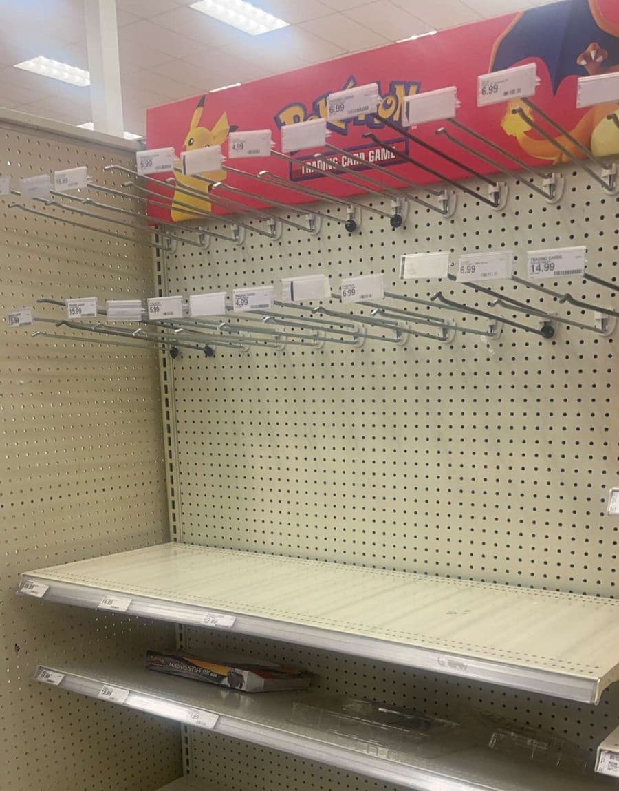 Empty Pokemon trading card pegs and shelving in a Target store