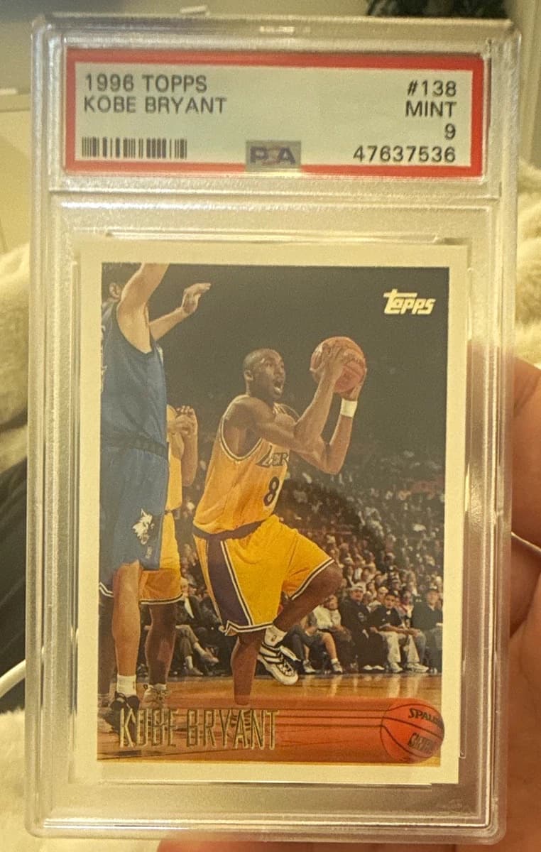 A 1996-97 Topps Kobe Bryant rookie card, number 138, in a PSA 9 slab