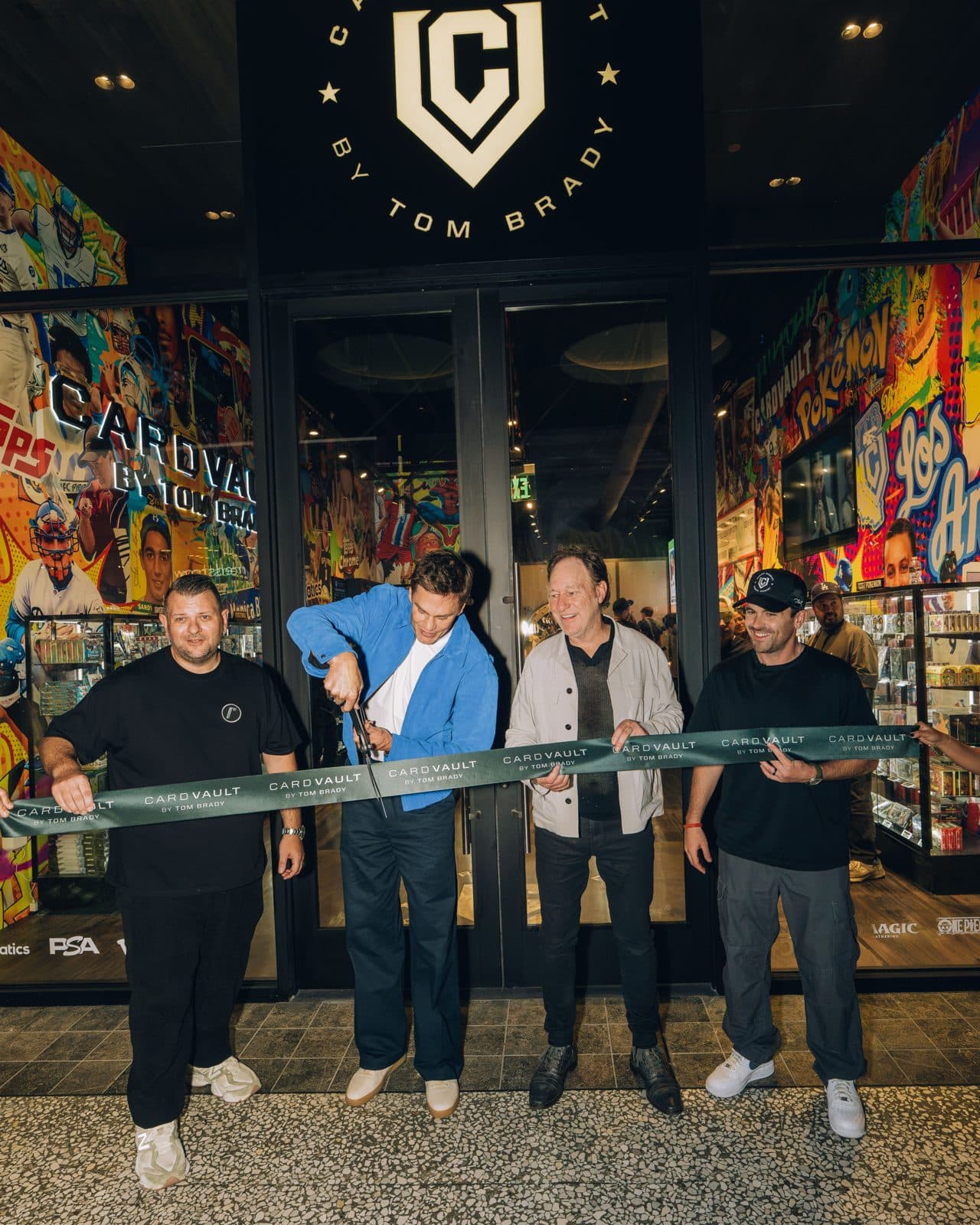Tom Brady cuts a ribbon at the entrance of the CardVault by Tom Brady store at Westfield Century City with the store's co-owners