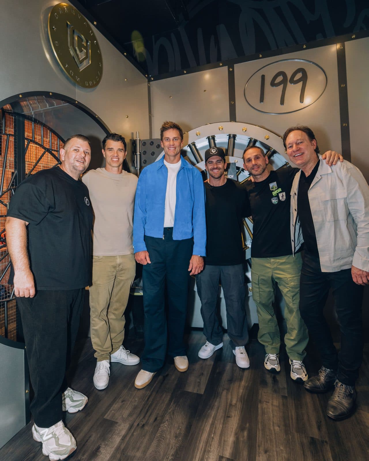 Tom Brady stands with Michael Rubin, Mike Mahan and the CardVault co-owners in front of the store's vault door