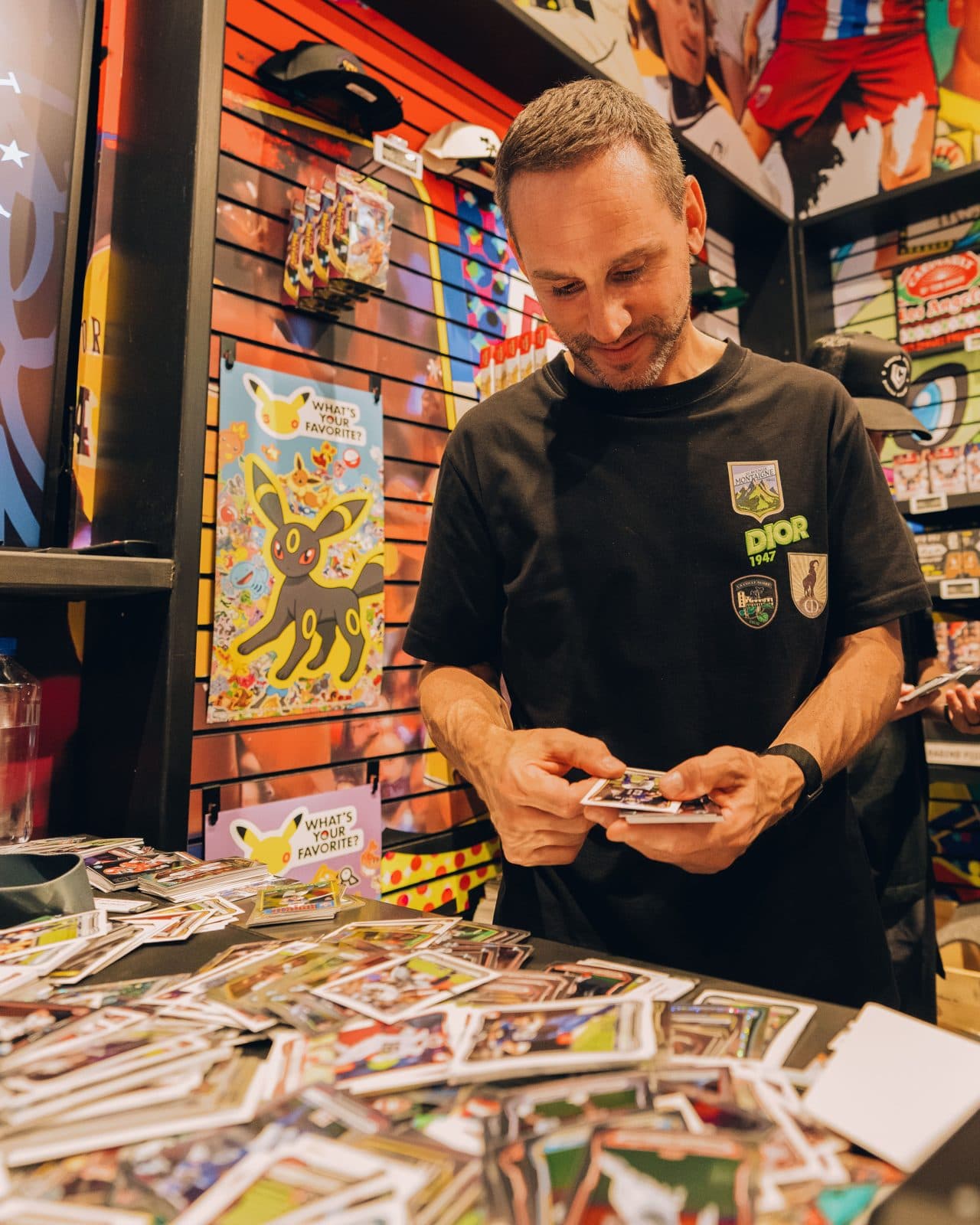 Michael Rubin opens a pack at a table covered in trading cards