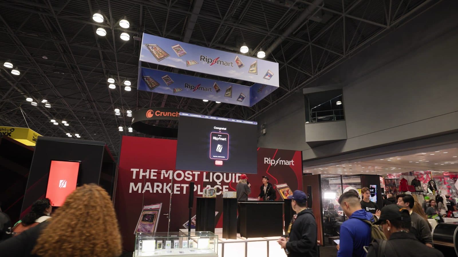 Crowds walk past the Ripmart booth and its overhead sign on the New York Comic Con show floor