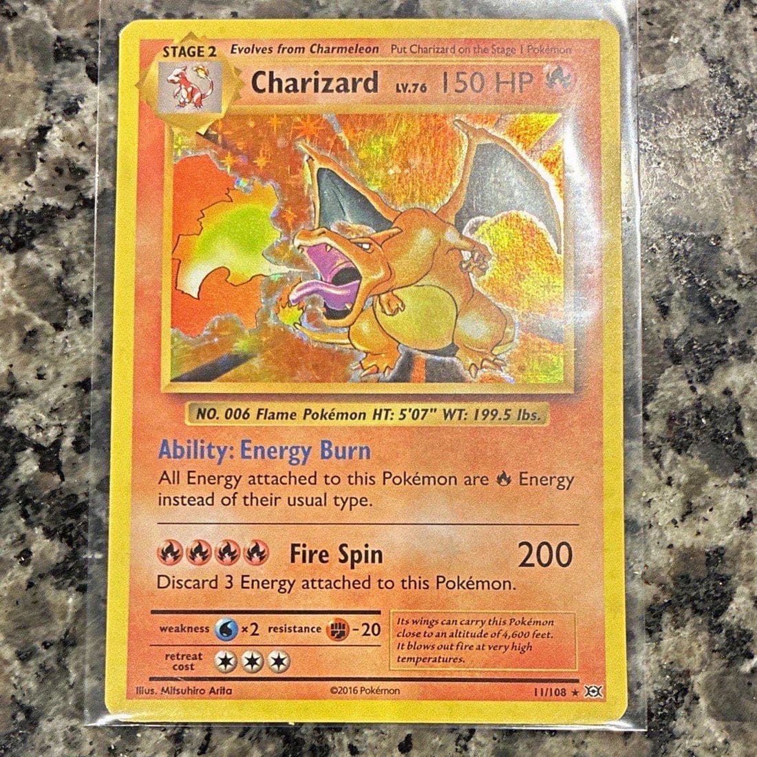 A raw 2016 Pokémon XY Evolutions Charizard holo, number 11