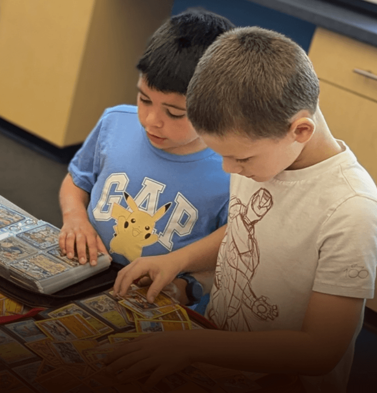 Children sorting and trading Pokémon cards together at a table